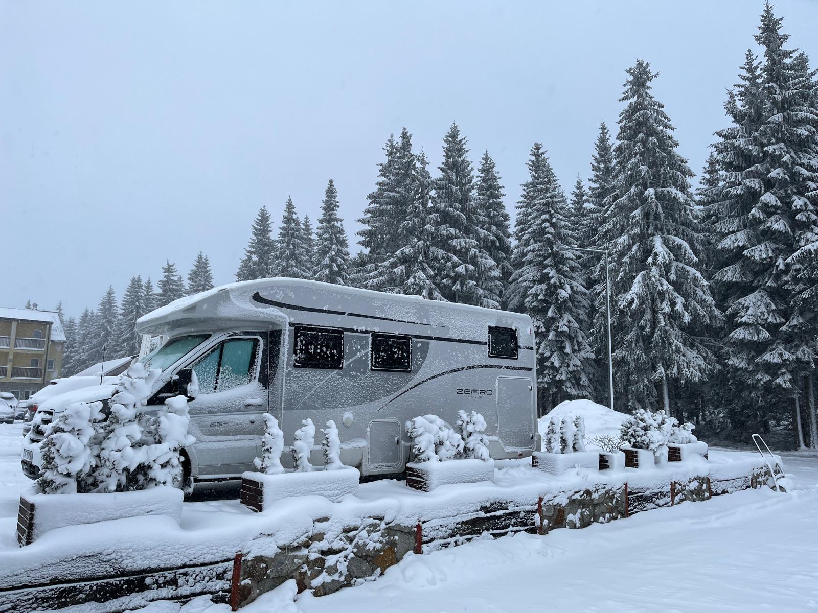 Kamper pod świeżym śniegiem w ośrodku zimowym